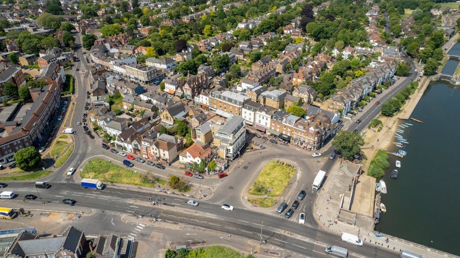 A row of traditional brick and white-painted terraced houses on Sidcup High Street, with multiple windows and storefronts at street level, some with signage visible. In front of the buildings, a busy 